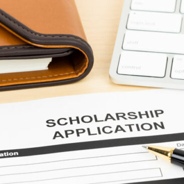 Printed scholarship application form with keyboard and pen